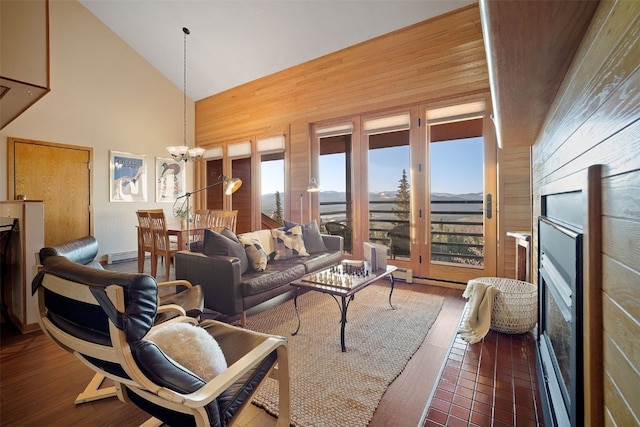 91400 Ryan Gulch Rd Unit 91425, Silverthorne, CO 80498 - living area featuring wooden walls, a chandelier, high vaulted ceiling, a fireplace, and wood finished floors