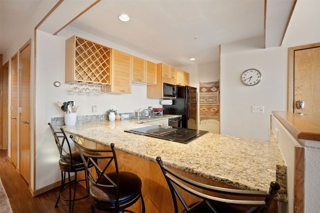 91400 Ryan Gulch Rd Unit 91425, Silverthorne, CO 80498 - kitchen with dark wood finished floors, a peninsula, black appliances, a sink, and a kitchen breakfast bar