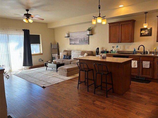 2379 Abbey Ct Unit 3, Steamboat Springs, CO 80487 - kitchen with open floor plan, a kitchen island, a kitchen bar, dark wood-type flooring, and a sink