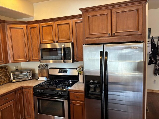 2379 Abbey Ct Unit 3, Steamboat Springs, CO 80487 - kitchen featuring appliances with stainless steel finishes, brown cabinetry, and light countertops