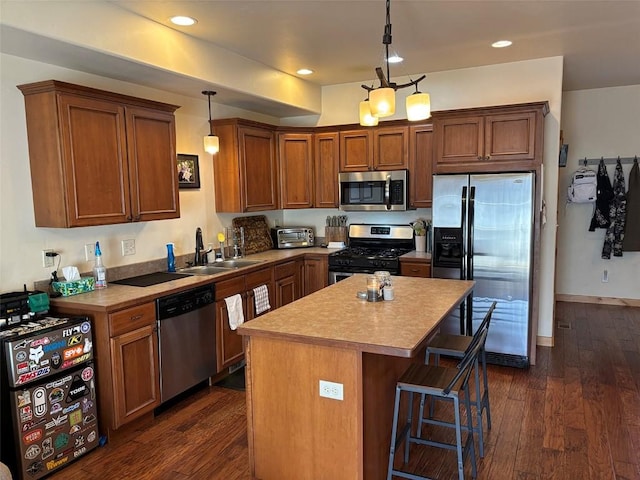 2379 Abbey Ct Unit 3, Steamboat Springs, CO 80487 - kitchen featuring stainless steel appliances, a sink, a center island, dark wood finished floors, and a breakfast bar area