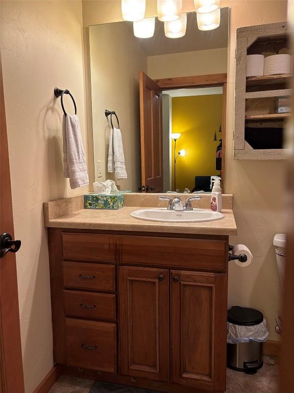 2379 Abbey Ct Unit 3, Steamboat Springs, CO 80487 - half bath with vanity, toilet, tile patterned flooring, and baseboards