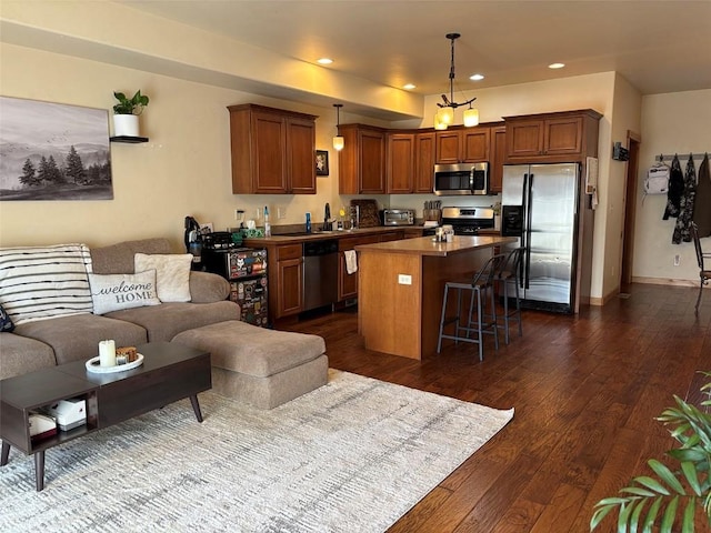 2379 Abbey Ct Unit 3, Steamboat Springs, CO 80487 - kitchen with appliances with stainless steel finishes, a center island, open floor plan, dark wood-style flooring, and recessed lighting