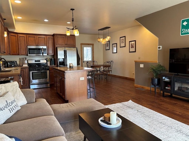 2379 Abbey Ct Unit 3, Steamboat Springs, CO 80487 - kitchen featuring stainless steel appliances, a center island, a breakfast bar area, dark wood-type flooring, and a sink