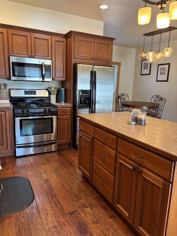 2379 Abbey Ct Unit 3, Steamboat Springs, CO 80487 - kitchen featuring stainless steel appliances, dark wood-type flooring, light countertops, brown cabinetry, and recessed lighting