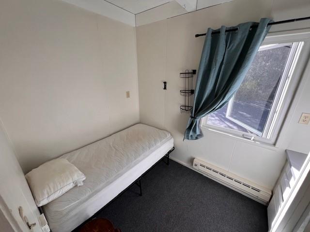 carpeted bedroom with a baseboard heating unit