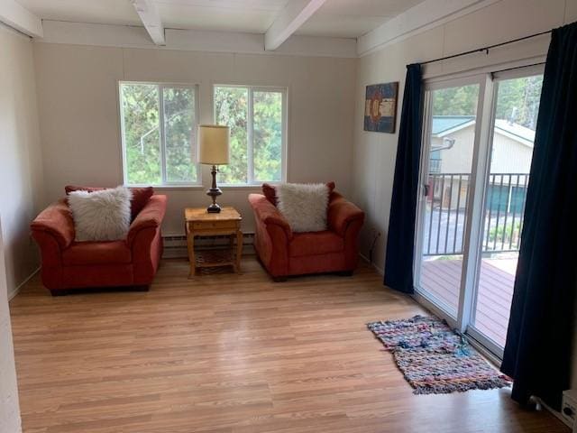 sitting room with beamed ceiling, healthy amount of natural light, light wood-style flooring, and a baseboard heating unit