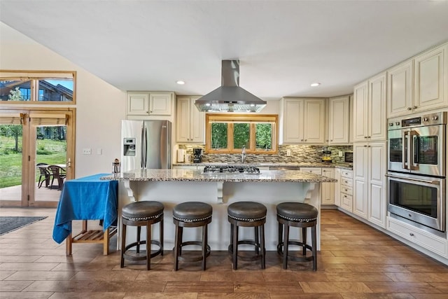 12 Raindance Trl, Dillon, CO 80435 - kitchen featuring appliances with stainless steel finishes, ventilation hood, a center island, light stone counters, and tasteful backsplash