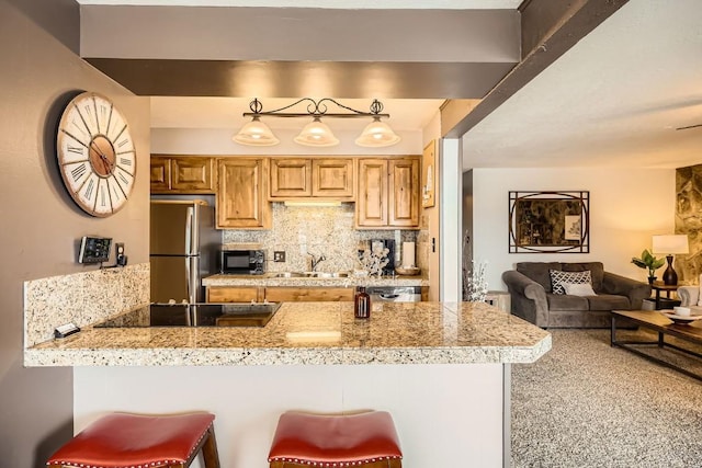 120 E Ln Bonte St Unit 109, Dillon, CO 80435 - kitchen with a sink, black appliances, tile counters, a peninsula, and tasteful backsplash