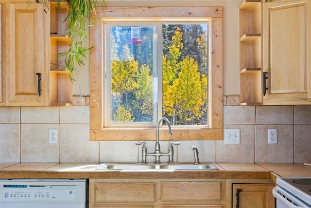 kitchen featuring backsplash, white dishwasher, sink, light brown cabinets, and tile counters