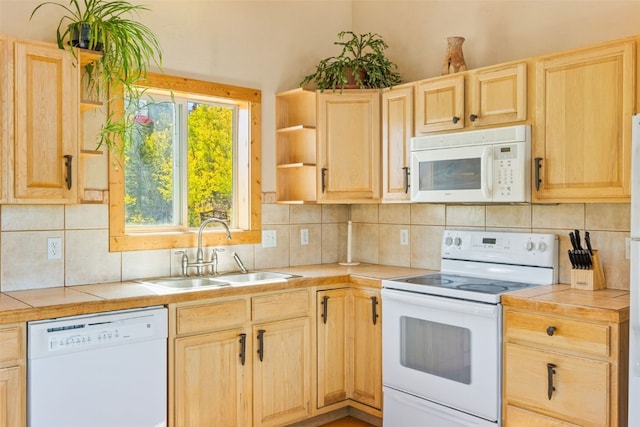 kitchen featuring tile counters, decorative backsplash, white appliances, and sink