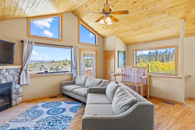 living room with a stone fireplace, ceiling fan, wooden ceiling, and light hardwood / wood-style floors