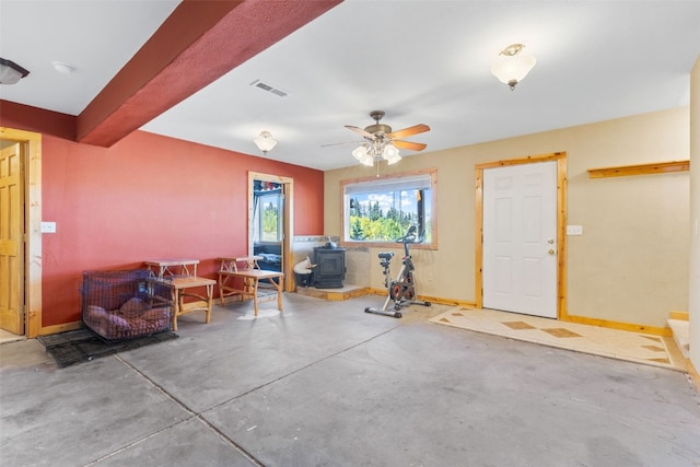 interior space featuring a wood stove and ceiling fan