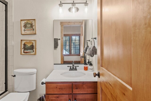 bathroom with toilet, a shower with door, and vanity