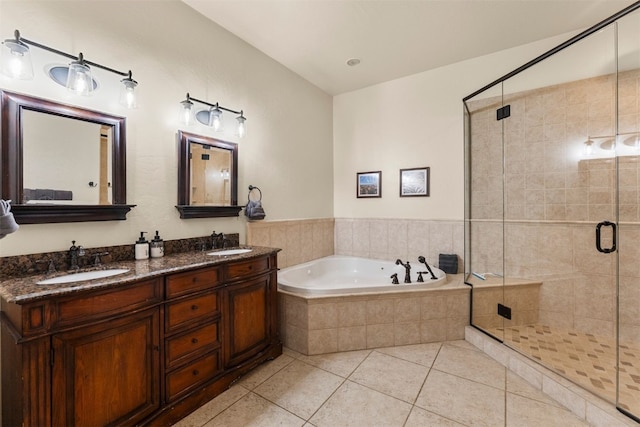 bathroom with a shower stall, a sink, a bath, and tile patterned floors