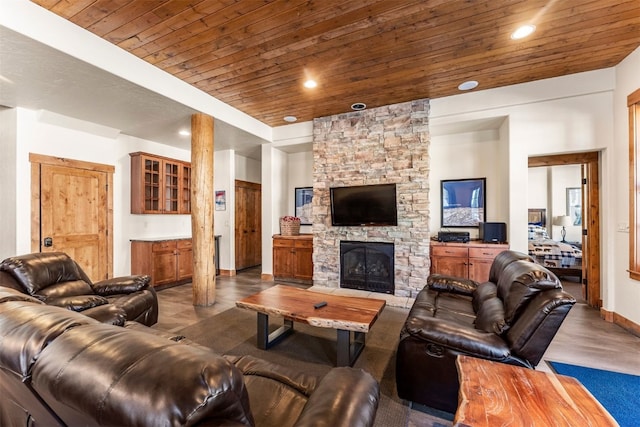 living area with wooden ceiling, recessed lighting, baseboards, and a stone fireplace