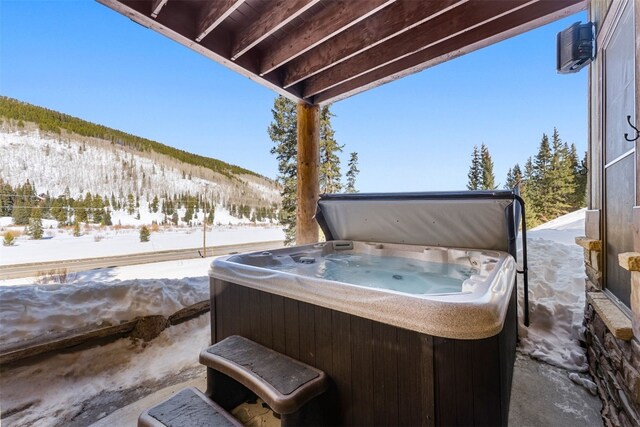 snow covered patio featuring a hot tub