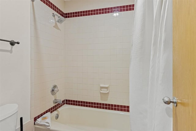 bathroom featuring shower / tub combo with curtain and toilet