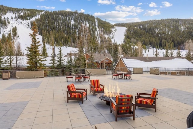 snow covered patio featuring a fire pit