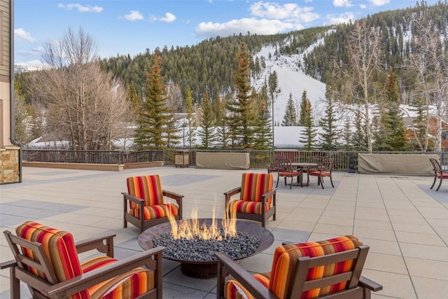 snow covered patio with an outdoor fire pit