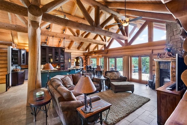 living room with log walls, beam ceiling, french doors, and ceiling fan