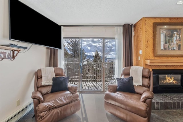 living area with wooden walls, a baseboard radiator, a fireplace, and a textured ceiling