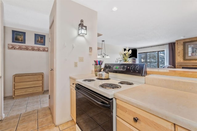 kitchen featuring light brown cabinetry, light countertops, range with electric stovetop, and light tile patterned floors