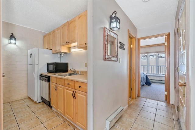 kitchen featuring stainless steel dishwasher, light brown cabinetry, a baseboard heating unit, a sink, and black microwave