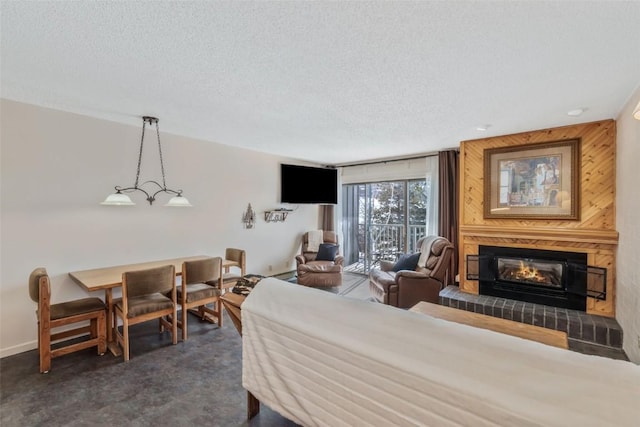 bedroom with a textured ceiling, dark carpet, a fireplace, and access to exterior