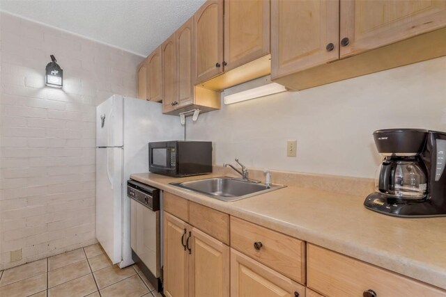 kitchen featuring light countertops, light brown cabinetry, a sink, black microwave, and dishwasher