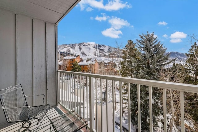 snow covered back of property with a mountain view