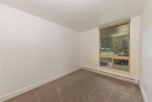 carpeted empty room with a baseboard heating unit