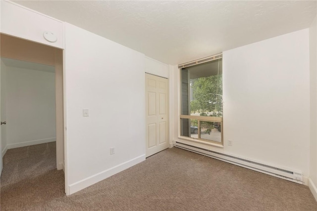 empty room featuring carpet floors and baseboard heating