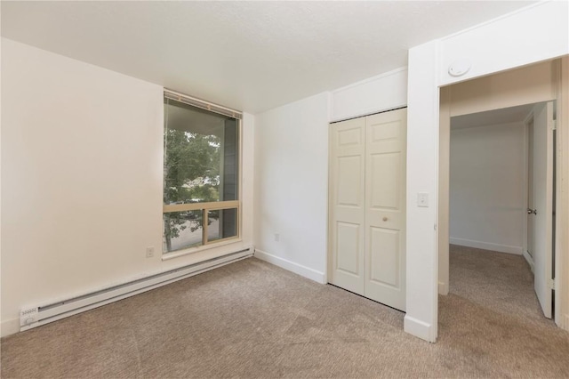 unfurnished bedroom with a baseboard radiator, a closet, and light colored carpet