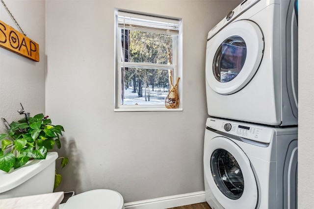 laundry room with a wealth of natural light and stacked washer and dryer