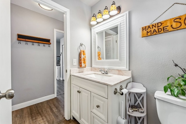 bathroom with hardwood / wood-style floors, toilet, and vanity