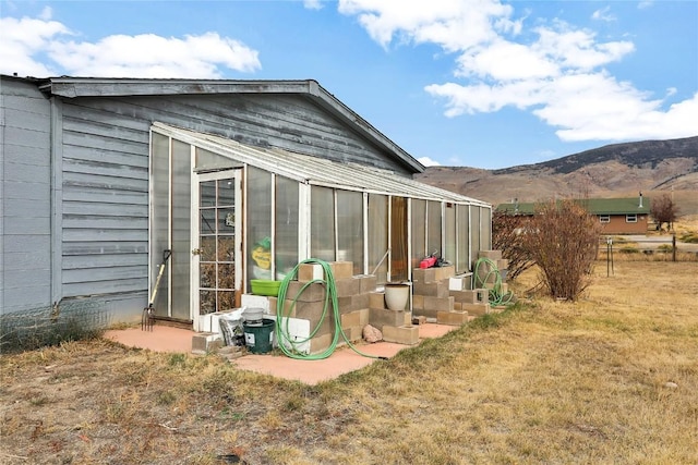 view of outbuilding featuring a mountain view and a lawn