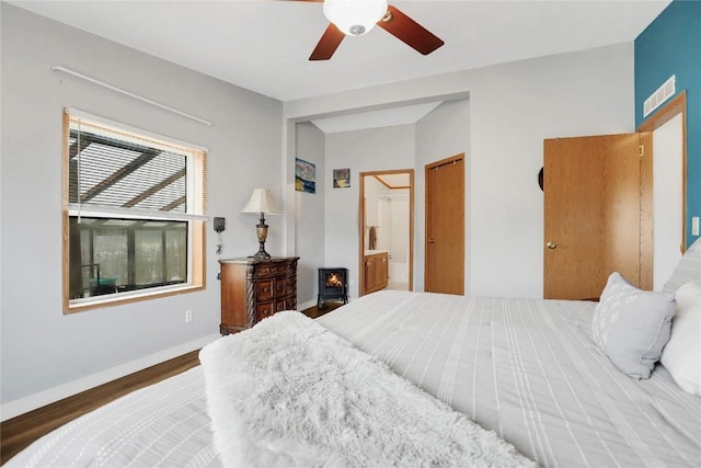 bedroom featuring connected bathroom, dark hardwood / wood-style floors, and ceiling fan