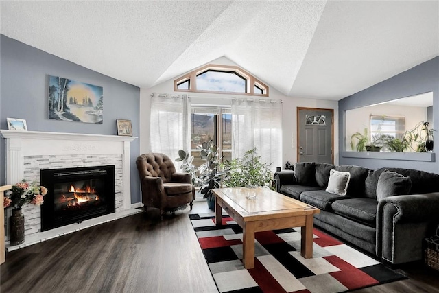 living room featuring a textured ceiling, dark wood-type flooring, a fireplace, and vaulted ceiling