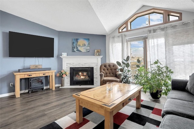 living room featuring a fireplace, a textured ceiling, dark hardwood / wood-style floors, and vaulted ceiling