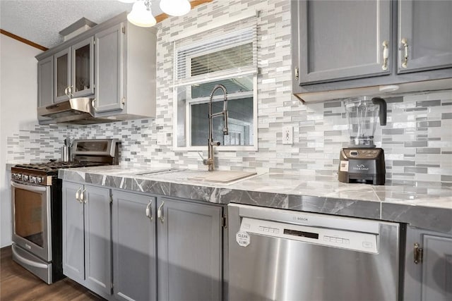 kitchen featuring a textured ceiling, stainless steel appliances, gray cabinets, and sink