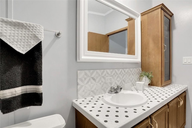 bathroom featuring backsplash, vanity, and toilet