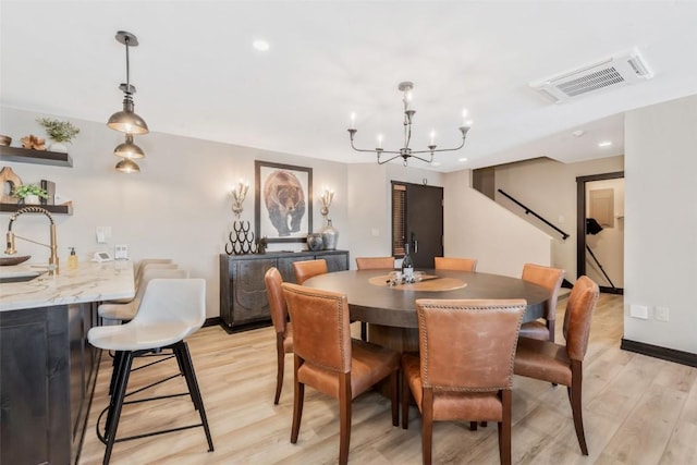 dining area featuring a notable chandelier, recessed lighting, visible vents, baseboards, and light wood finished floors