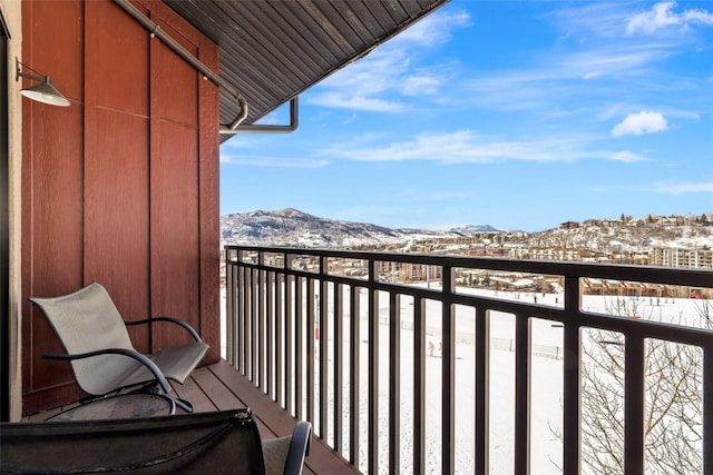 snow covered back of property featuring a mountain view