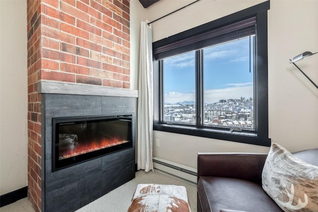 interior space with a baseboard heating unit, a fireplace, and carpet flooring