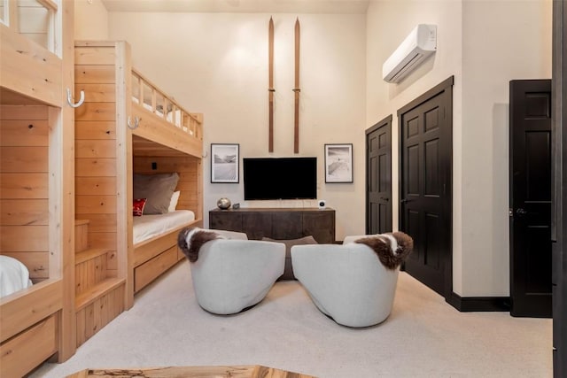 bedroom with light carpet, a towering ceiling, baseboards, and a wall mounted AC