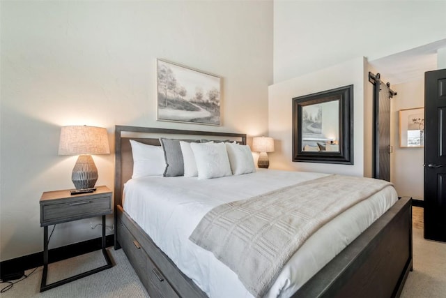 carpeted bedroom featuring a barn door