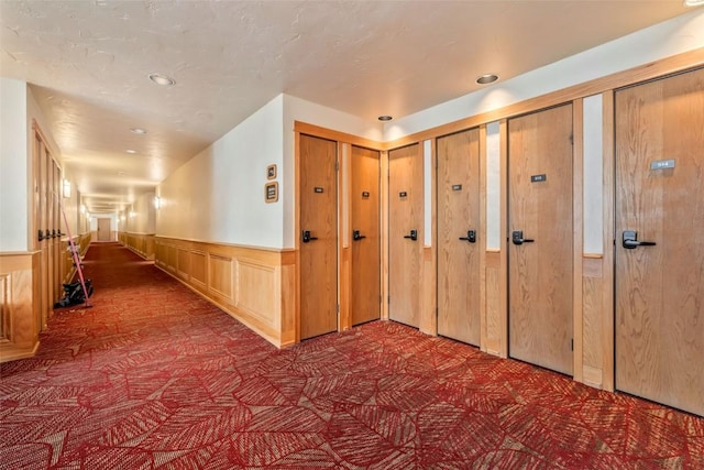 hallway featuring carpet floors, recessed lighting, and a wainscoted wall