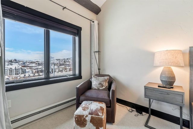 living area featuring baseboards, a baseboard heating unit, and a wealth of natural light