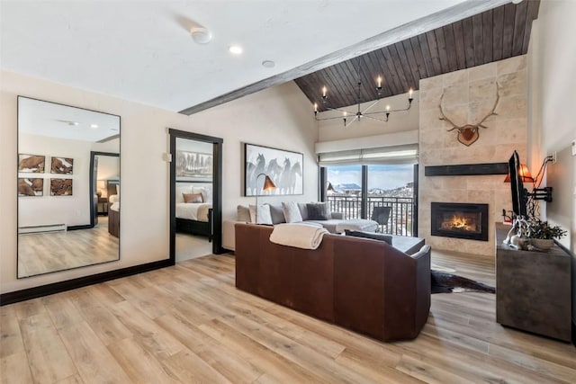 living area featuring lofted ceiling, recessed lighting, baseboard heating, a tiled fireplace, and light wood-type flooring